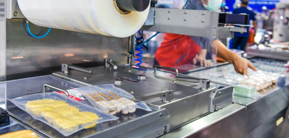 Food items going through a vacuum sealing production process.