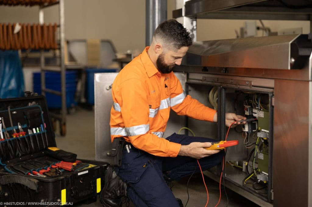 Handheld thermal imaging camera scanning an industrial vacuum pump to diagnose overheating hotspots during troubleshooting